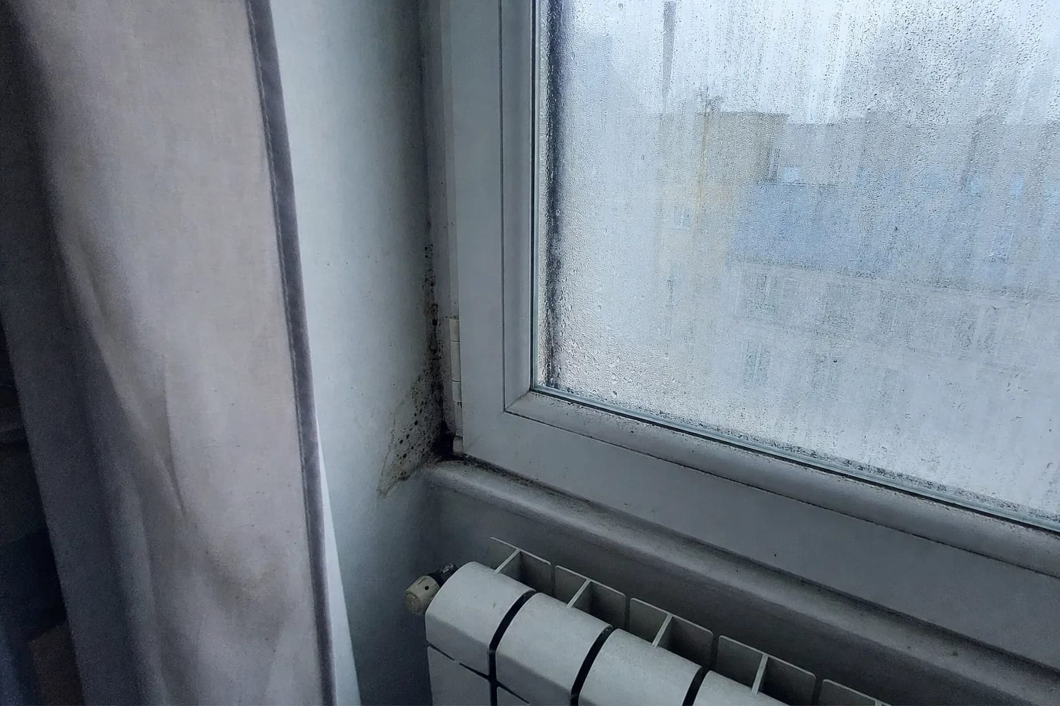 Buée de condensation sur une fenêtre d'appartement au petit matin