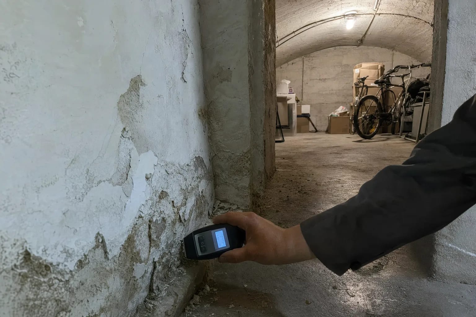 Expert bâtiment relevant le taux d'humidité d'un mur avec un humidimètre